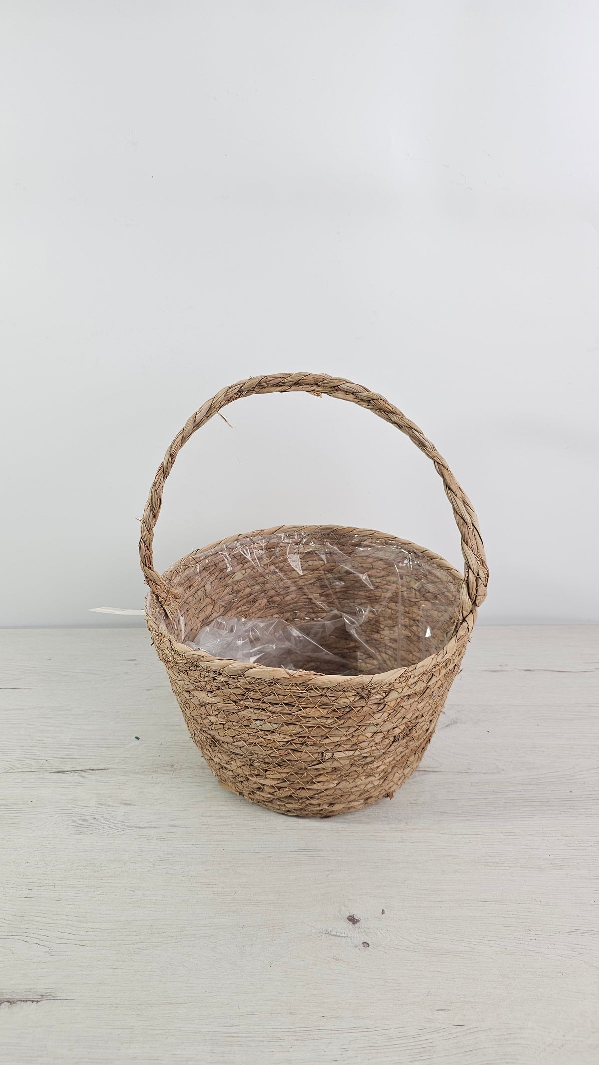 Cesta de fibra natural con forro interior de plástico para plantas y centros.