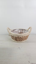 Cesta redonda de cuerda y fibra natural con asas, estilo artesanal.