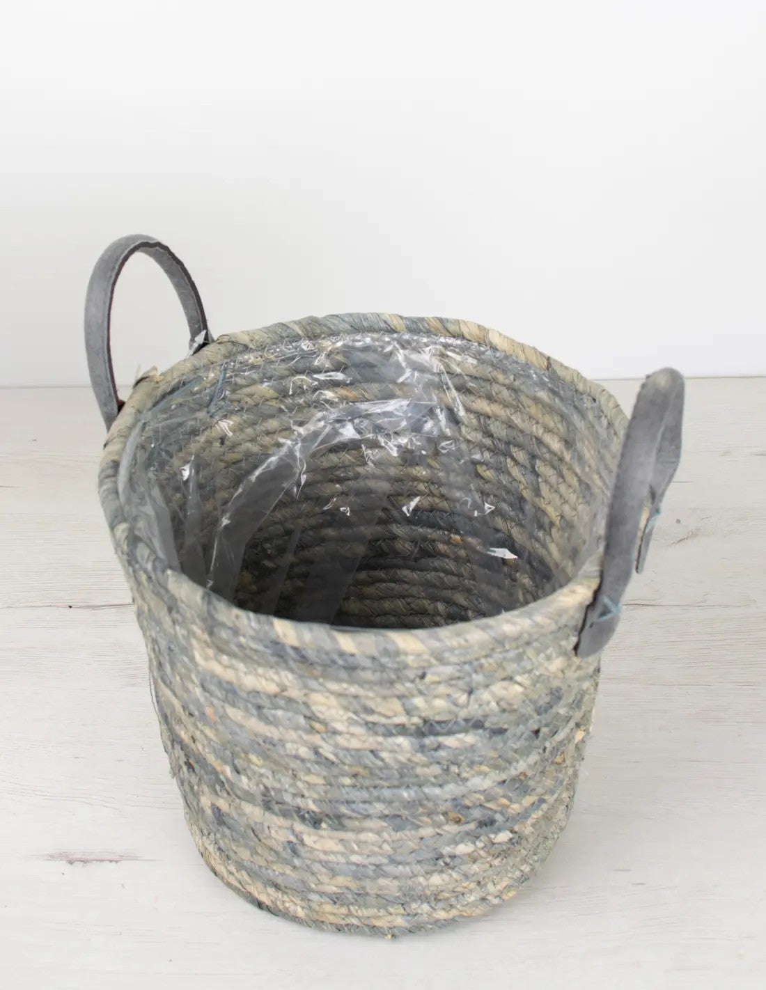 Cesta decorativa en fibras naturales con matices azules para plantas de interior.  
