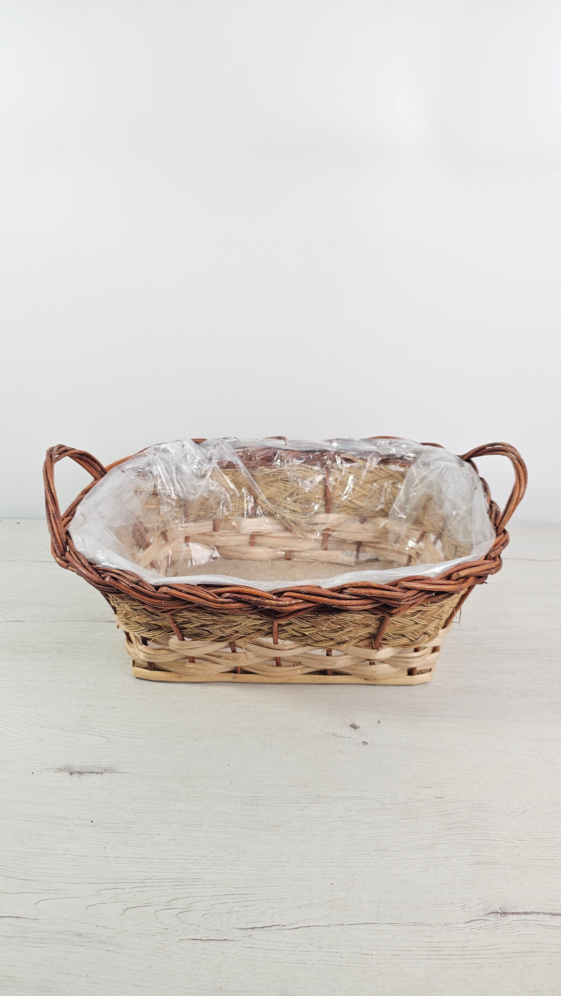 Cesta de mimbre, esparto y anea de fibras naturales con acabado artesanal.  