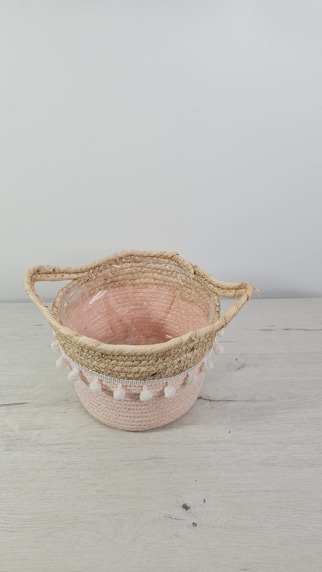 Cesta de mimbre rosa con asas ideal como cubremacetas de interior