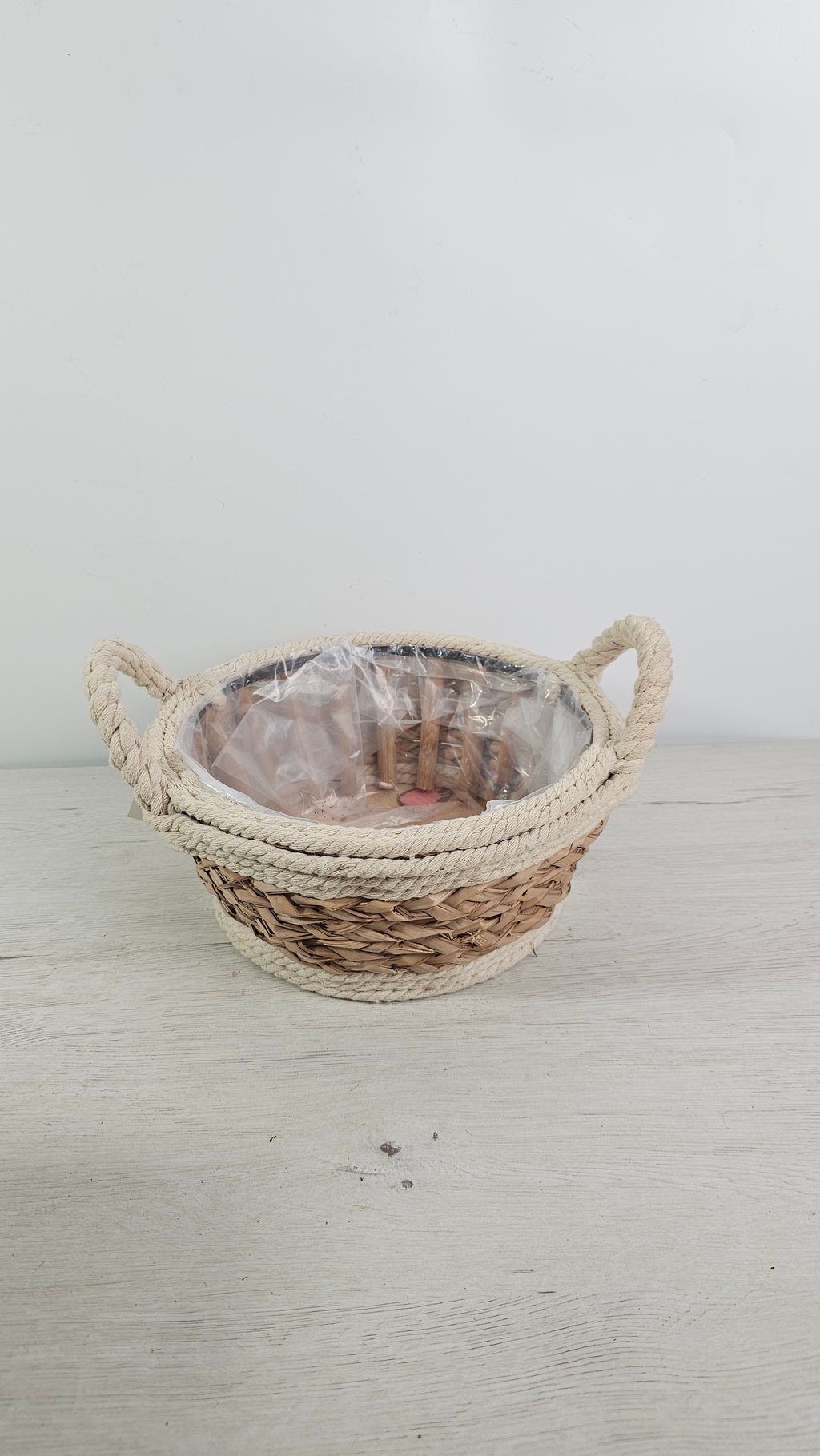 Cesta de fibras naturales con forro interior de plástico para plantas y centros.