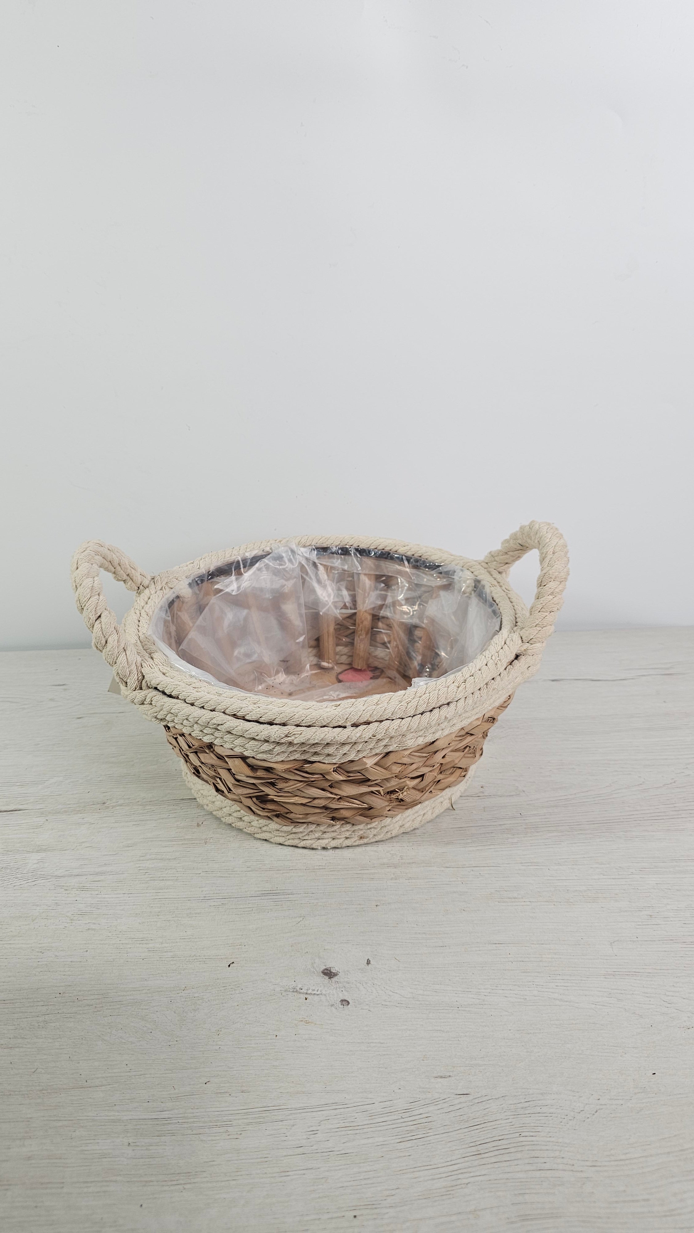 Cesta de fibras naturales con forro interior de plástico para plantas y centros.