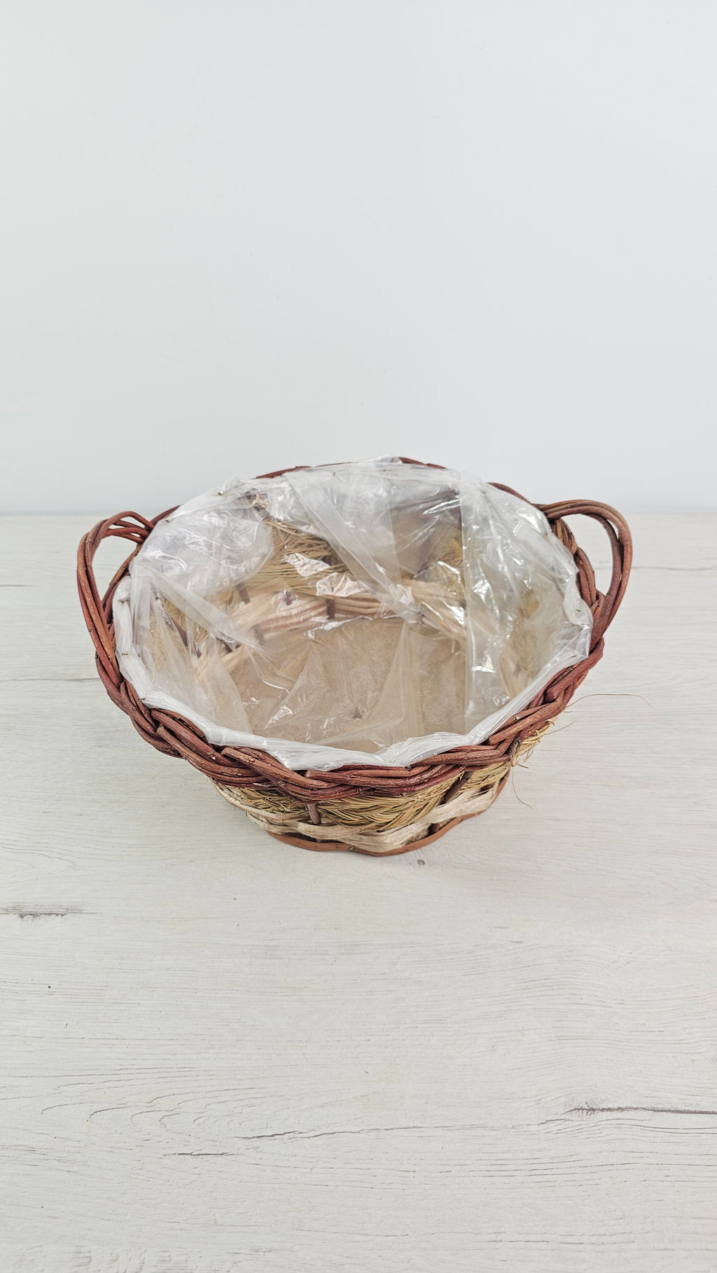 Cesta de mimbre y esparto con forro interior de plástico para proteger de la humedad.  