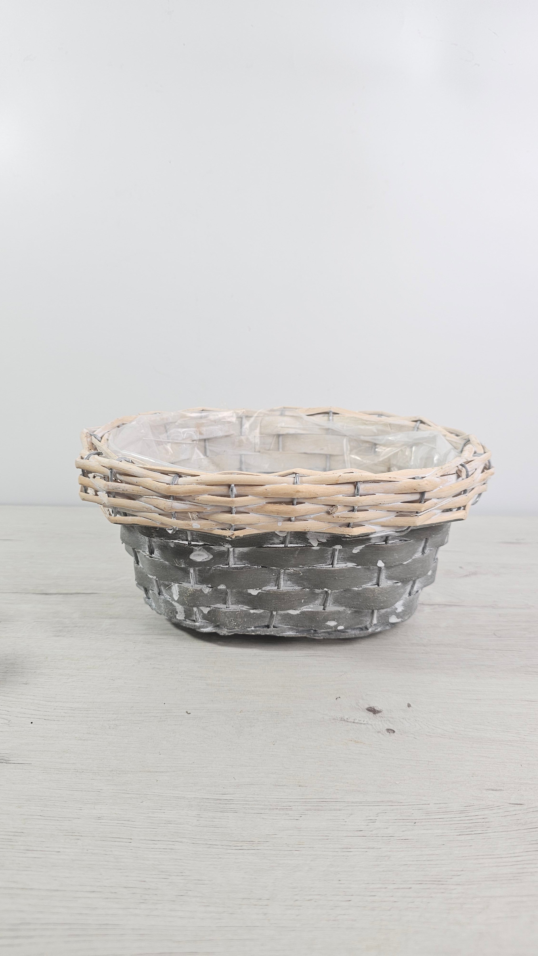 Cesta redonda gris y natural con forro interior de plástico. 