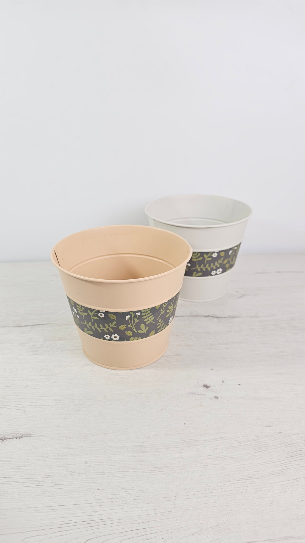 Cubremaceta de zinc pintado en verde menta con franja decorativa floral.