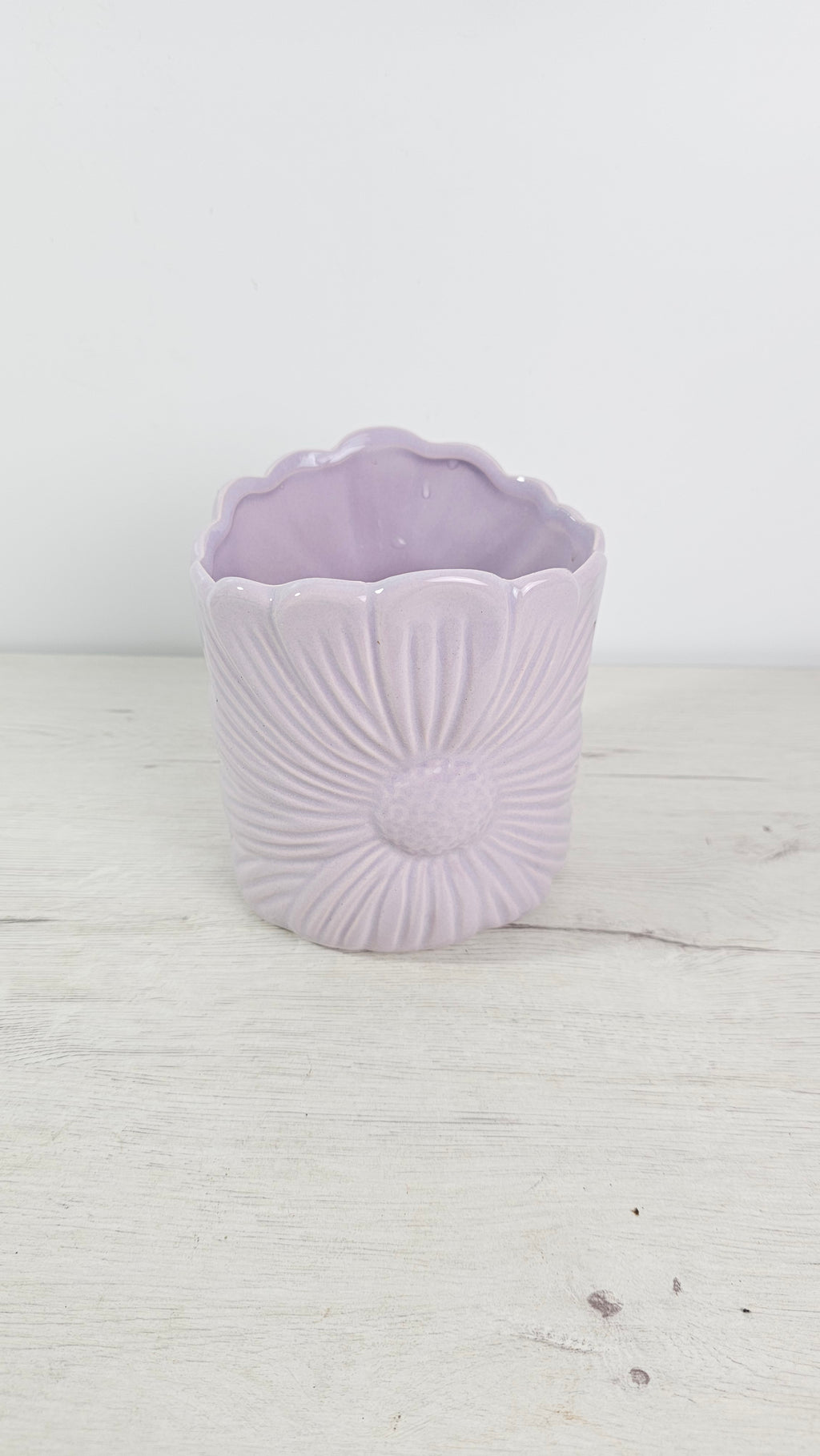 Cubremacetas Bloomy de cerámica color lila con flor esculpida en relieve.
