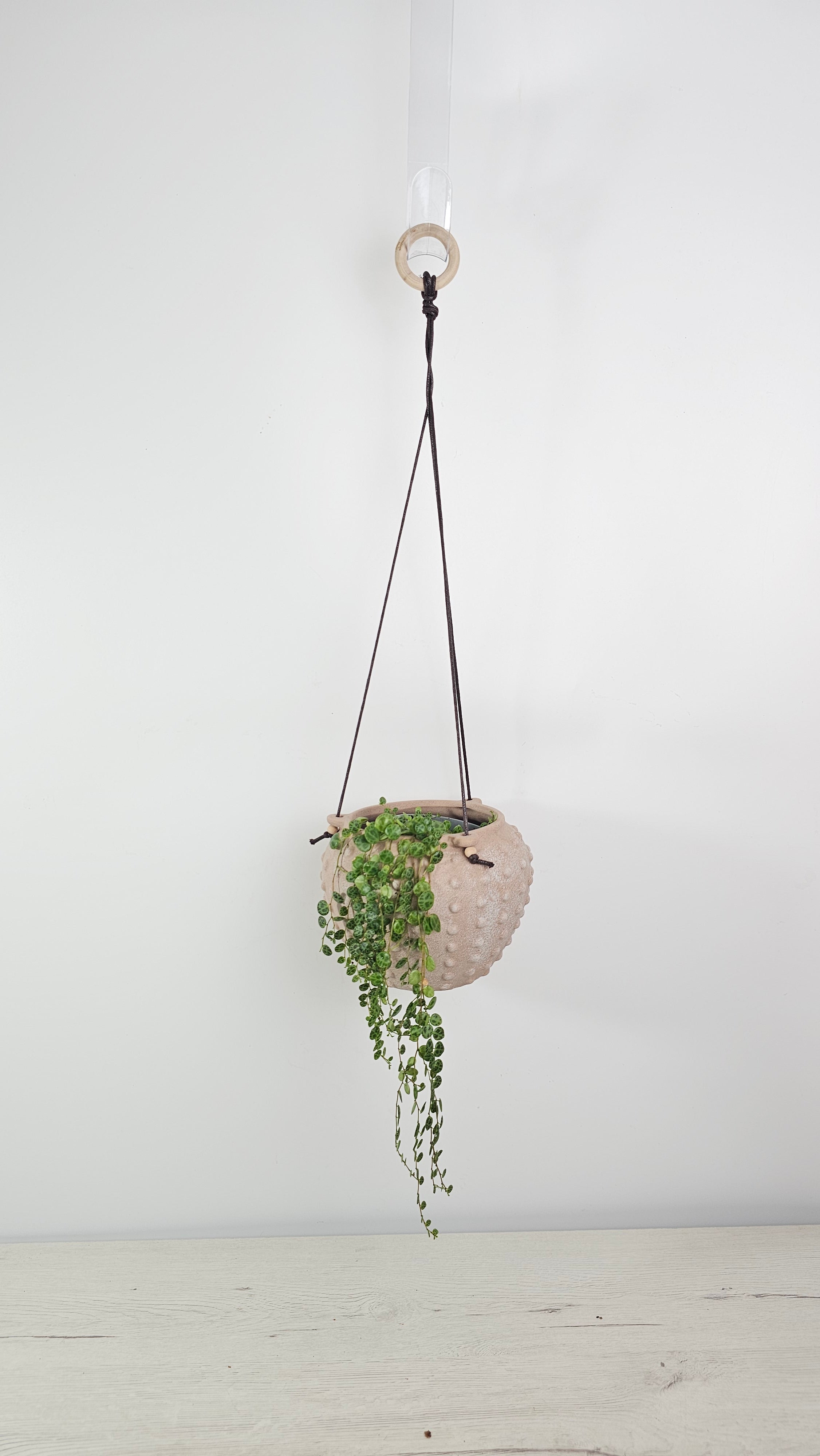 Cubremacetas colgante con relieve y acabado texturizado para decorar interiores con plantas.