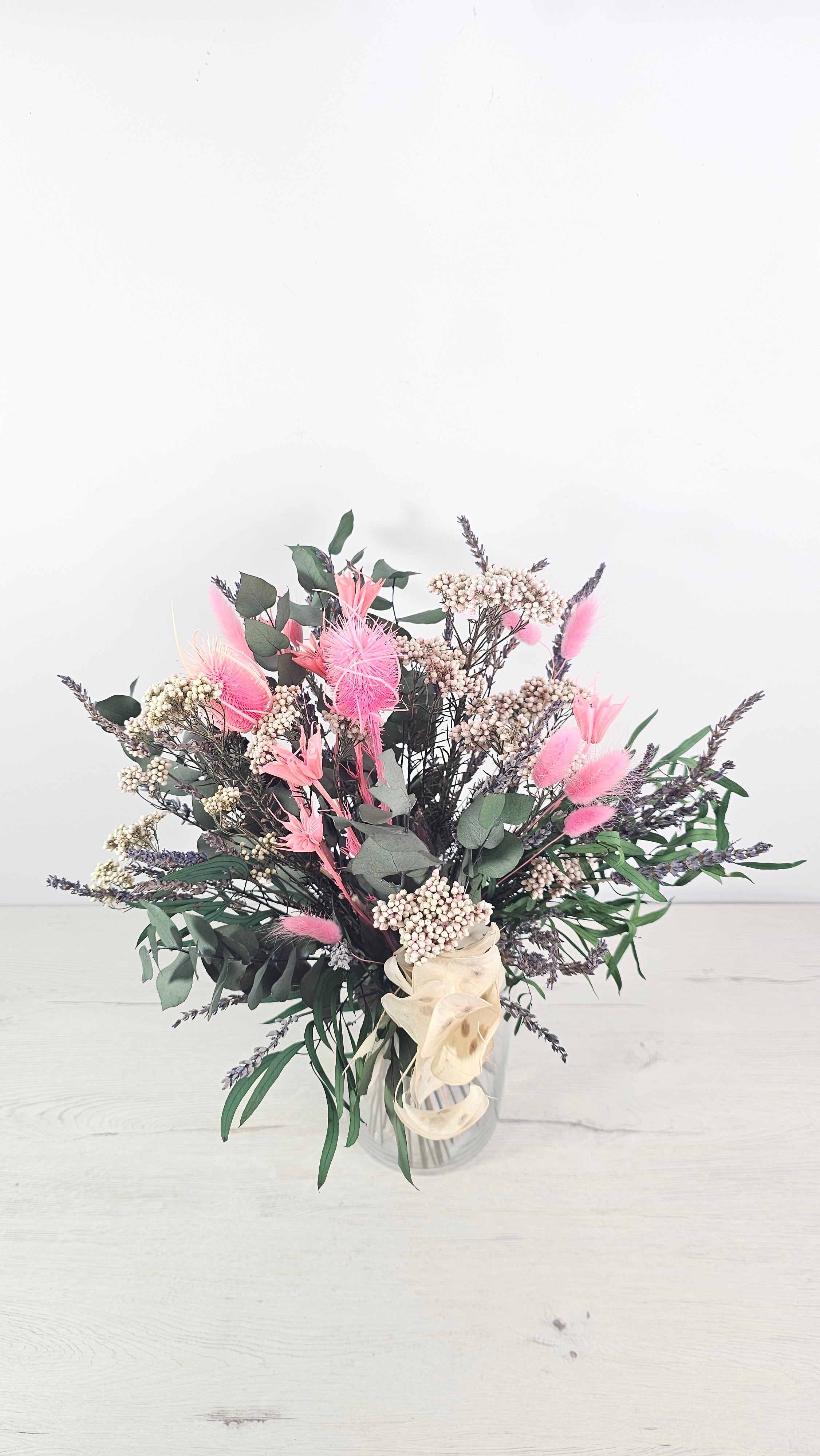 Detalle de flores preservadas en rosa combinadas con verdes naturales.  